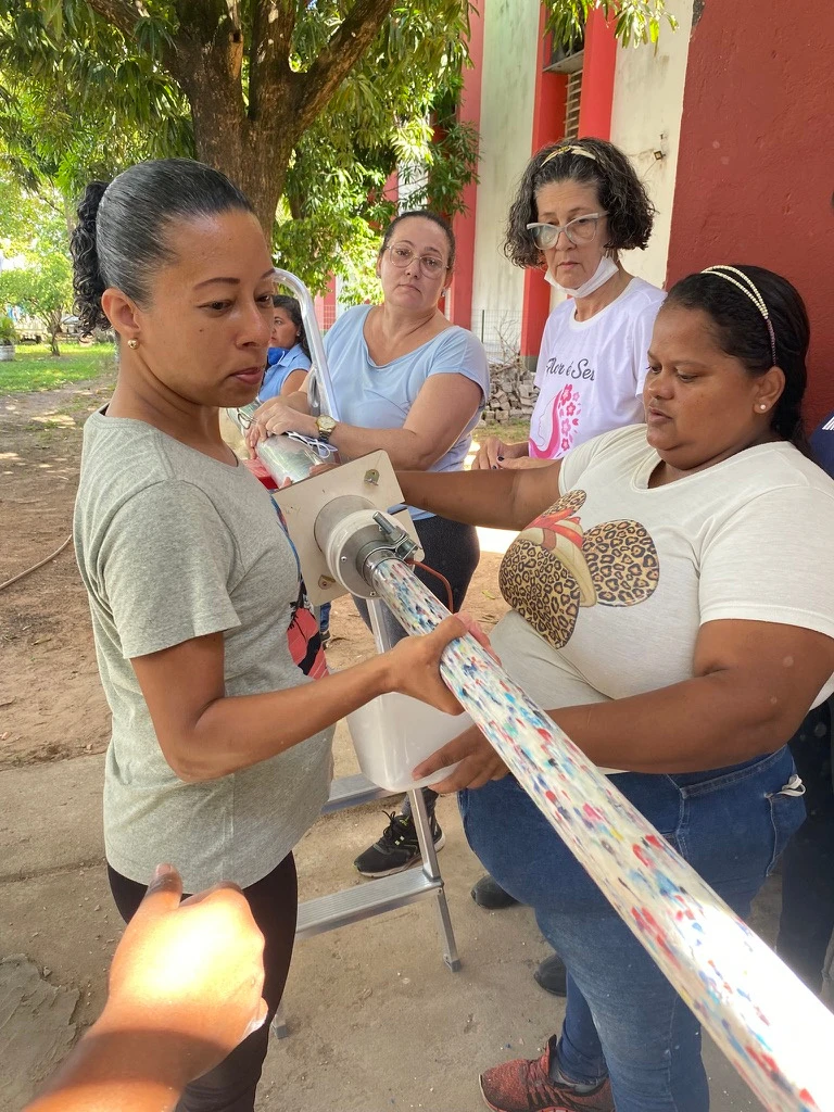 Mulheres trabalhando juntas na montagem de uma peça